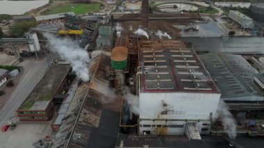 Cinematic Flight Over Vast British Sugar Factory Infrastructure With Large Storage Silos And Exhaust Plumes