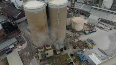Cinematic Flight Over Vast British Sugar Factory Infrastructure With Large Storage Silos And Exhaust Plumes