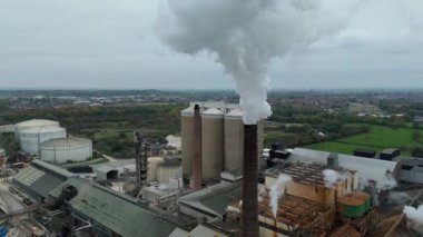 Cinematic Flight Over Vast British Sugar Factory Infrastructure With Large Storage Silos And Exhaust Plumes