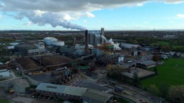 Cinematic Flight Over Vast British Sugar Factory Infrastructure With Large Storage Silos And Exhaust Plumes