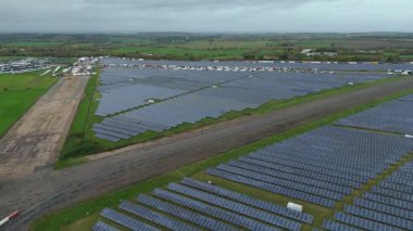 İngiliz kırsal kesimindeki eski RAF Üs Taksiyollarında inşa edilen Büyük Endüstriyel Güneş Çiftliği Altyapısı Üzerine Sinematik Uçuş