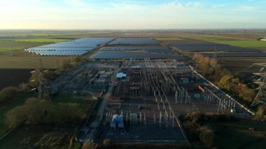 Günbatımında temiz enerji entegrasyonunu gösteren Cambridgeshire İngiltere 'deki geniş Burwell alt istasyonu ve güneş enerjisi santralinin hava görüntüsü.