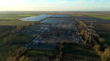 Günbatımında temiz enerji entegrasyonunu gösteren Cambridgeshire İngiltere 'deki geniş Burwell alt istasyonu ve güneş enerjisi santralinin hava görüntüsü.