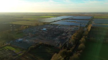 Günbatımında temiz enerji entegrasyonunu gösteren Cambridgeshire İngiltere 'deki geniş Burwell alt istasyonu ve güneş enerjisi santralinin hava görüntüsü.
