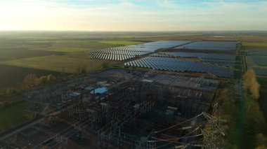 Günbatımında temiz enerji entegrasyonunu gösteren Cambridgeshire İngiltere 'deki geniş Burwell alt istasyonu ve güneş enerjisi santralinin hava görüntüsü.