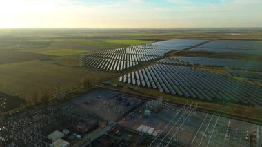 Günbatımında temiz enerji entegrasyonunu gösteren Cambridgeshire İngiltere 'deki geniş Burwell alt istasyonu ve güneş enerjisi santralinin hava görüntüsü.