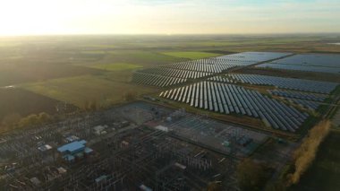 Günbatımında temiz enerji entegrasyonunu gösteren Cambridgeshire İngiltere 'deki geniş Burwell alt istasyonu ve güneş enerjisi santralinin hava görüntüsü.