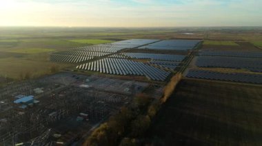 Günbatımında temiz enerji entegrasyonunu gösteren Cambridgeshire İngiltere 'deki geniş Burwell alt istasyonu ve güneş enerjisi santralinin hava görüntüsü.