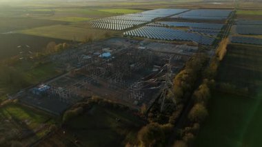 Günbatımında temiz enerji entegrasyonunu gösteren Cambridgeshire İngiltere 'deki geniş Burwell alt istasyonu ve güneş enerjisi santralinin hava görüntüsü.