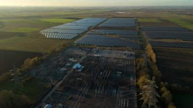Günbatımında temiz enerji entegrasyonunu gösteren Cambridgeshire İngiltere 'deki geniş Burwell alt istasyonu ve güneş enerjisi santralinin hava görüntüsü.