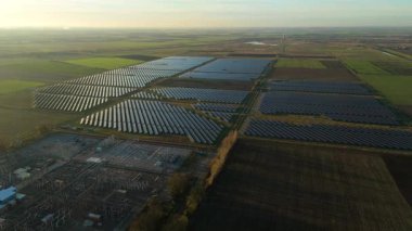 Günbatımında temiz enerji entegrasyonunu gösteren Cambridgeshire İngiltere 'deki geniş Burwell alt istasyonu ve güneş enerjisi santralinin hava görüntüsü.
