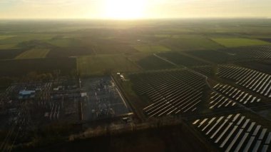 Günbatımında temiz enerji entegrasyonunu gösteren Cambridgeshire İngiltere 'deki geniş Burwell alt istasyonu ve güneş enerjisi santralinin hava görüntüsü.