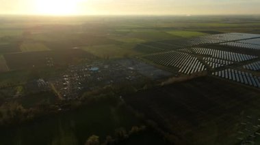 Günbatımında temiz enerji entegrasyonunu gösteren Cambridgeshire İngiltere 'deki geniş Burwell alt istasyonu ve güneş enerjisi santralinin hava görüntüsü.
