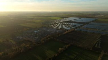 Günbatımında temiz enerji entegrasyonunu gösteren Cambridgeshire İngiltere 'deki geniş Burwell alt istasyonu ve güneş enerjisi santralinin hava görüntüsü.