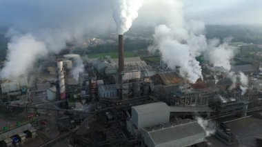 Bury St Edmunds UK 'deki İngiliz Şeker Fabrikası' nın hava aracı görüntüsünde duman bulutları ve şeker pancarı işleme için endüstriyel silolar yer alıyor..