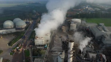 Bury St Edmunds UK 'deki İngiliz Şeker Fabrikası' nın hava aracı görüntüsünde duman bulutları ve şeker pancarı işleme için endüstriyel silolar yer alıyor..