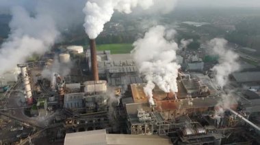 Bury St Edmunds UK 'deki İngiliz Şeker Fabrikası' nın hava aracı görüntüsünde duman bulutları ve şeker pancarı işleme için endüstriyel silolar yer alıyor..