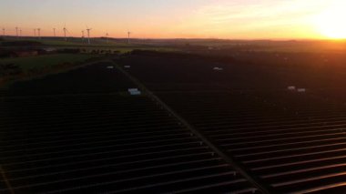 Birleşik Krallık 'taki altın saat boyunca gün batımında muazzam bir güneş enerjisi santralinin çarpıcı hava manzarası.