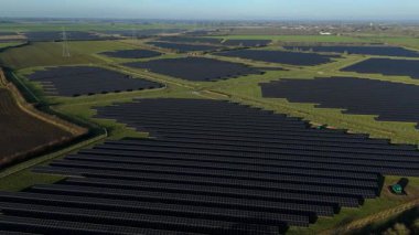 Birleşik Krallık 'taki altın saat boyunca gün batımında muazzam bir güneş enerjisi santralinin çarpıcı hava manzarası.