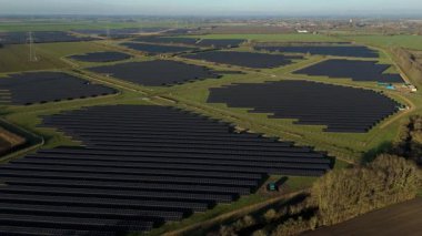 Birleşik Krallık 'taki altın saat boyunca gün batımında muazzam bir güneş enerjisi santralinin çarpıcı hava manzarası.