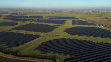 Birleşik Krallık 'taki altın saat boyunca gün batımında muazzam bir güneş enerjisi santralinin çarpıcı hava manzarası.