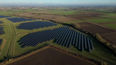 Birleşik Krallık 'taki altın saat boyunca gün batımında muazzam bir güneş enerjisi santralinin çarpıcı hava manzarası.