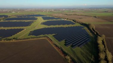 Birleşik Krallık 'taki altın saat boyunca gün batımında muazzam bir güneş enerjisi santralinin çarpıcı hava manzarası.