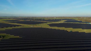Birleşik Krallık 'taki altın saat boyunca gün batımında muazzam bir güneş enerjisi santralinin çarpıcı hava manzarası.