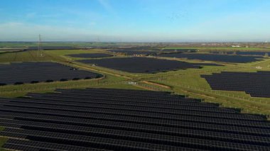 Birleşik Krallık 'taki altın saat boyunca gün batımında muazzam bir güneş enerjisi santralinin çarpıcı hava manzarası.