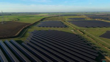 Birleşik Krallık 'taki altın saat boyunca gün batımında muazzam bir güneş enerjisi santralinin çarpıcı hava manzarası.