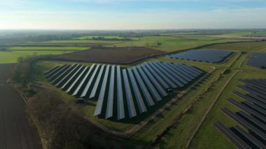 Birleşik Krallık 'taki altın saat boyunca gün batımında muazzam bir güneş enerjisi santralinin çarpıcı hava manzarası.