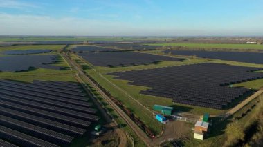 Birleşik Krallık 'taki altın saat boyunca gün batımında muazzam bir güneş enerjisi santralinin çarpıcı hava manzarası.