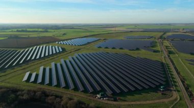 Birleşik Krallık 'taki altın saat boyunca gün batımında muazzam bir güneş enerjisi santralinin çarpıcı hava manzarası.