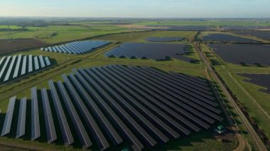 Birleşik Krallık 'taki altın saat boyunca gün batımında muazzam bir güneş enerjisi santralinin çarpıcı hava manzarası.