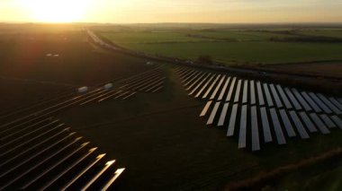 Birleşik Krallık 'taki altın saat boyunca gün batımında muazzam bir güneş enerjisi santralinin çarpıcı hava manzarası.