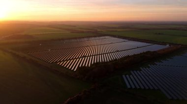 Birleşik Krallık 'taki altın saat boyunca gün batımında muazzam bir güneş enerjisi santralinin çarpıcı hava manzarası.