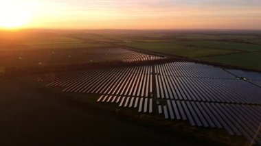 Birleşik Krallık 'taki altın saat boyunca gün batımında muazzam bir güneş enerjisi santralinin çarpıcı hava manzarası.