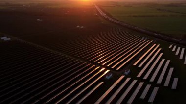 Birleşik Krallık 'taki altın saat boyunca gün batımında muazzam bir güneş enerjisi santralinin çarpıcı hava manzarası.