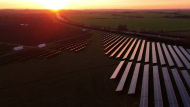 Birleşik Krallık 'taki altın saat boyunca gün batımında muazzam bir güneş enerjisi santralinin çarpıcı hava manzarası.