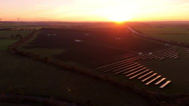 Birleşik Krallık 'taki altın saat boyunca gün batımında muazzam bir güneş enerjisi santralinin çarpıcı hava manzarası.