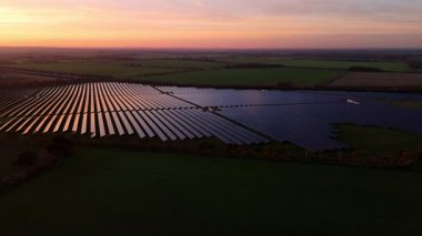 Birleşik Krallık 'taki altın saat boyunca gün batımında muazzam bir güneş enerjisi santralinin çarpıcı hava manzarası.