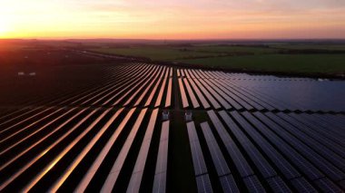 Birleşik Krallık 'taki altın saat boyunca gün batımında muazzam bir güneş enerjisi santralinin çarpıcı hava manzarası.