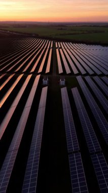 Birleşik Krallık 'taki altın saat boyunca gün batımında muazzam bir güneş enerjisi santralinin çarpıcı hava manzarası.