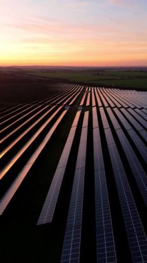 Birleşik Krallık 'taki altın saat boyunca gün batımında muazzam bir güneş enerjisi santralinin çarpıcı hava manzarası.