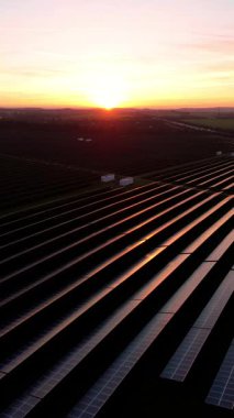 Birleşik Krallık 'taki altın saat boyunca gün batımında muazzam bir güneş enerjisi santralinin çarpıcı hava manzarası.