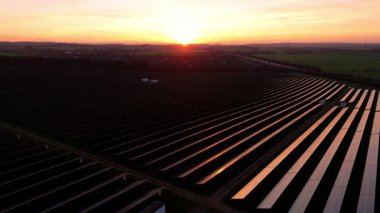 Birleşik Krallık 'taki altın saat boyunca gün batımında muazzam bir güneş enerjisi santralinin çarpıcı hava manzarası.