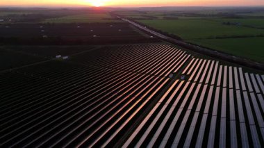 Birleşik Krallık 'taki altın saat boyunca gün batımında muazzam bir güneş enerjisi santralinin çarpıcı hava manzarası.