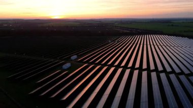 Birleşik Krallık 'taki altın saat boyunca gün batımında muazzam bir güneş enerjisi santralinin çarpıcı hava manzarası.