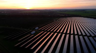 Birleşik Krallık 'taki altın saat boyunca gün batımında muazzam bir güneş enerjisi santralinin çarpıcı hava manzarası.