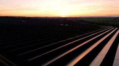 Birleşik Krallık 'taki altın saat boyunca gün batımında muazzam bir güneş enerjisi santralinin çarpıcı hava manzarası.